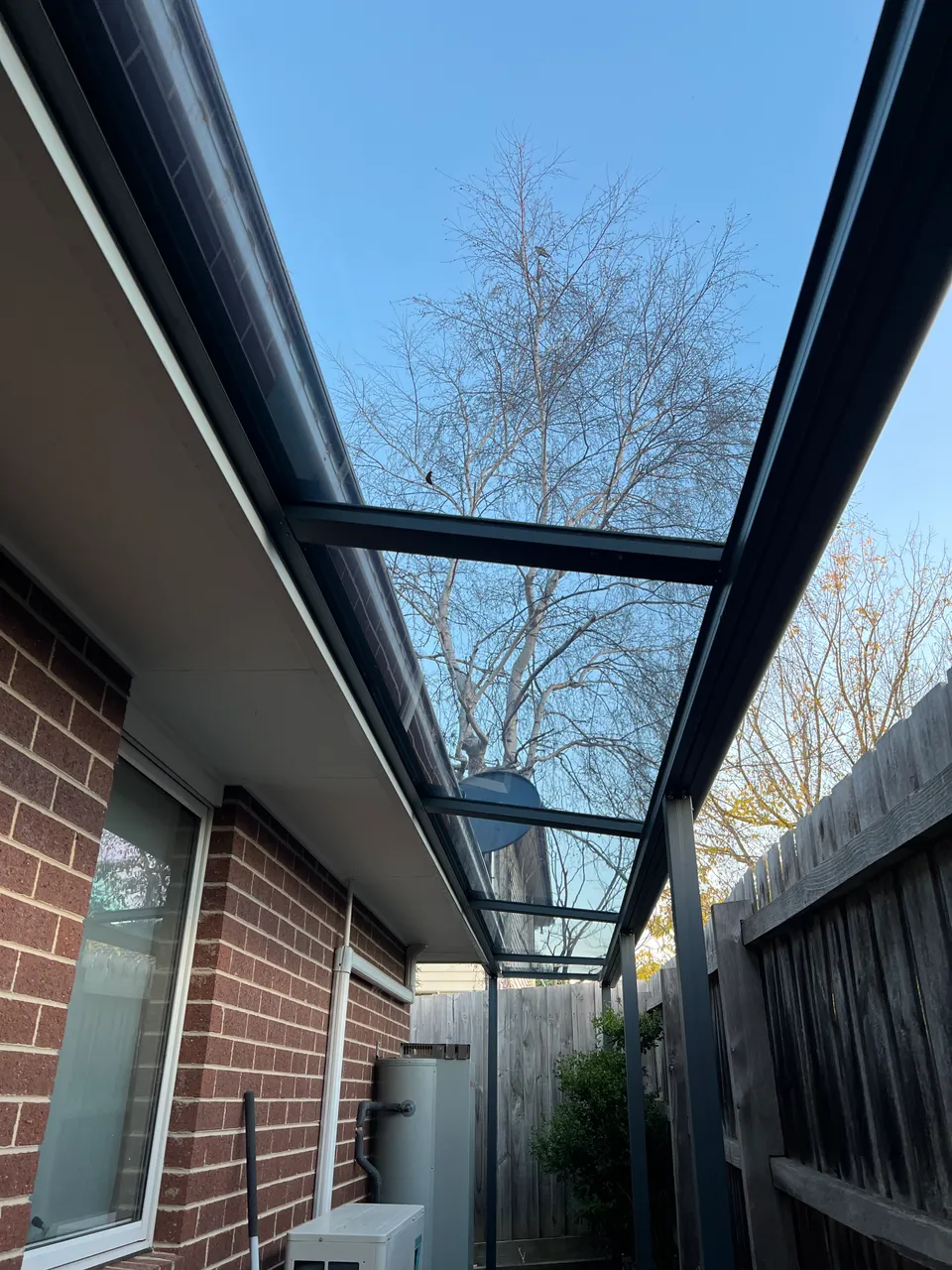 Clearview patio roofing connected to a brick home