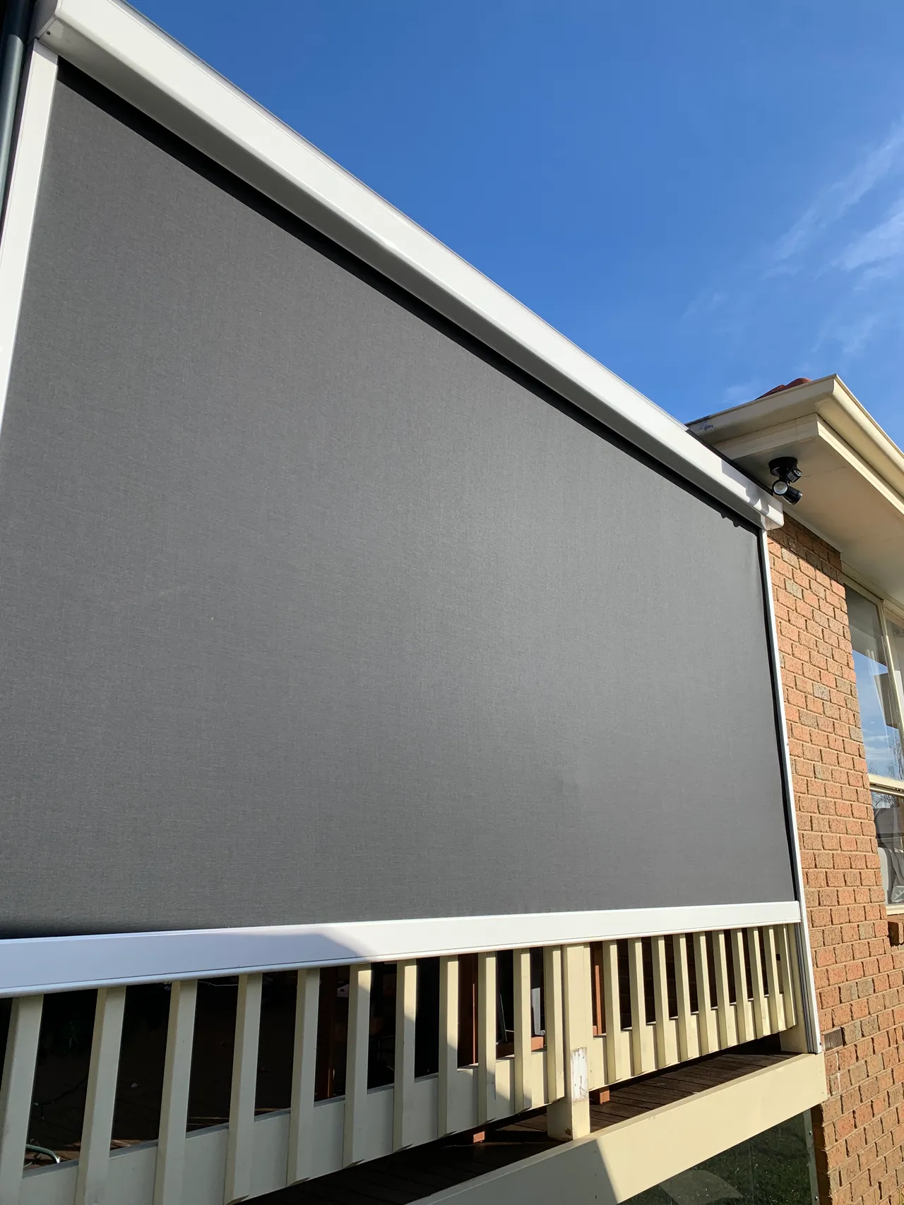 Outdoor blinds installed beside a covered patio